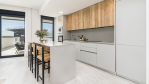 Een moderne keuken met een centraal eiland, houten kastjes en uitzicht op het buiten.