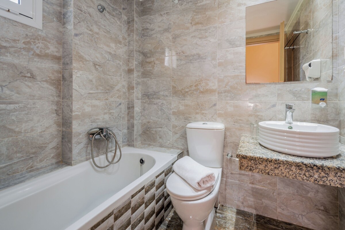 A bathroom with a bathtub, toilet, and sink.