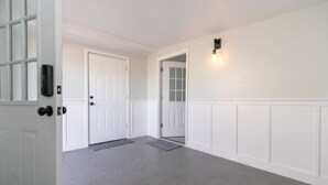 A hallway with white doors and a light fixture on the wall. - Cozy 2bd |10 min to Downtown Denver | Fast Wifi (Denver)