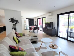 Relax in this stylish living space with a sofa, dining area, and kitchen, perfect for unwinding and enjoying the view.