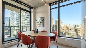 Een moderne vergaderruimte met een ronde tafel, zes stoelen en grote ramen met uitzicht op de stad.