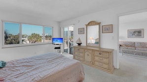 A bedroom with a bed, dresser, and a television. - HELLO SUNSHINE! FUN IN THE SAND! FAMILY ISLAND VACATION ON A BUDGET! (Fort Myers Beach)