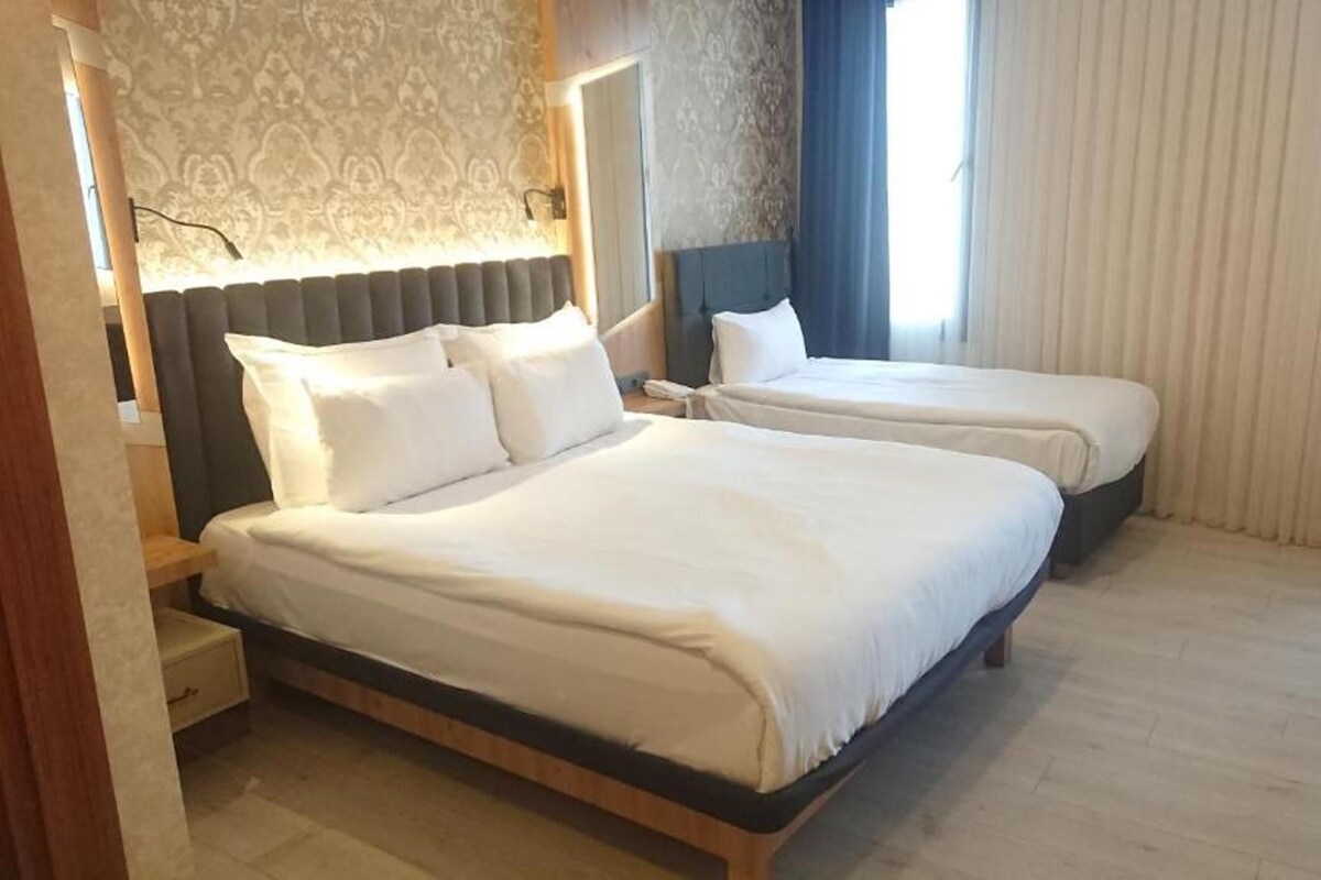 Una habitación de hotel con dos camas, un escritorio y una silla.