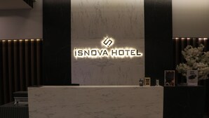 Una recepción con encimera de mármol y un cartel que dice 'ISNOVA HOTEL'.