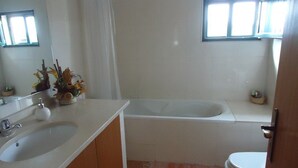 Ein Badezimmer mit Waschbecken, Spiegel und Badewanne.