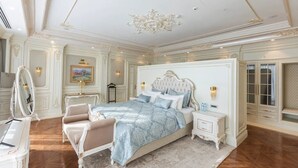 Un dormitorio lujoso con una cama grande, un tocador con espejo y un aparador.