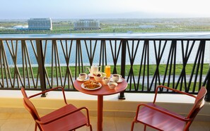 A balcony with a table set for breakfast, overlooking a body of water and distant buildings. - Savitsky Plaza (Samarkand)