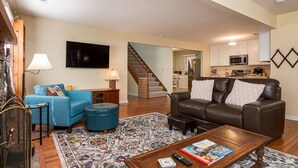 A living room with a blue sofa, a brown leather sofa, a coffee table, and a TV.