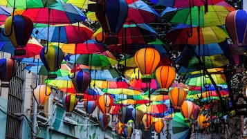 Una calle con sombrillas de colores y globos aerostáticos.