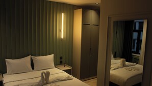A hotel room with a bed, a wardrobe, a nightstand, and a mirror. - Genoa Port Hotel (Istanbul)