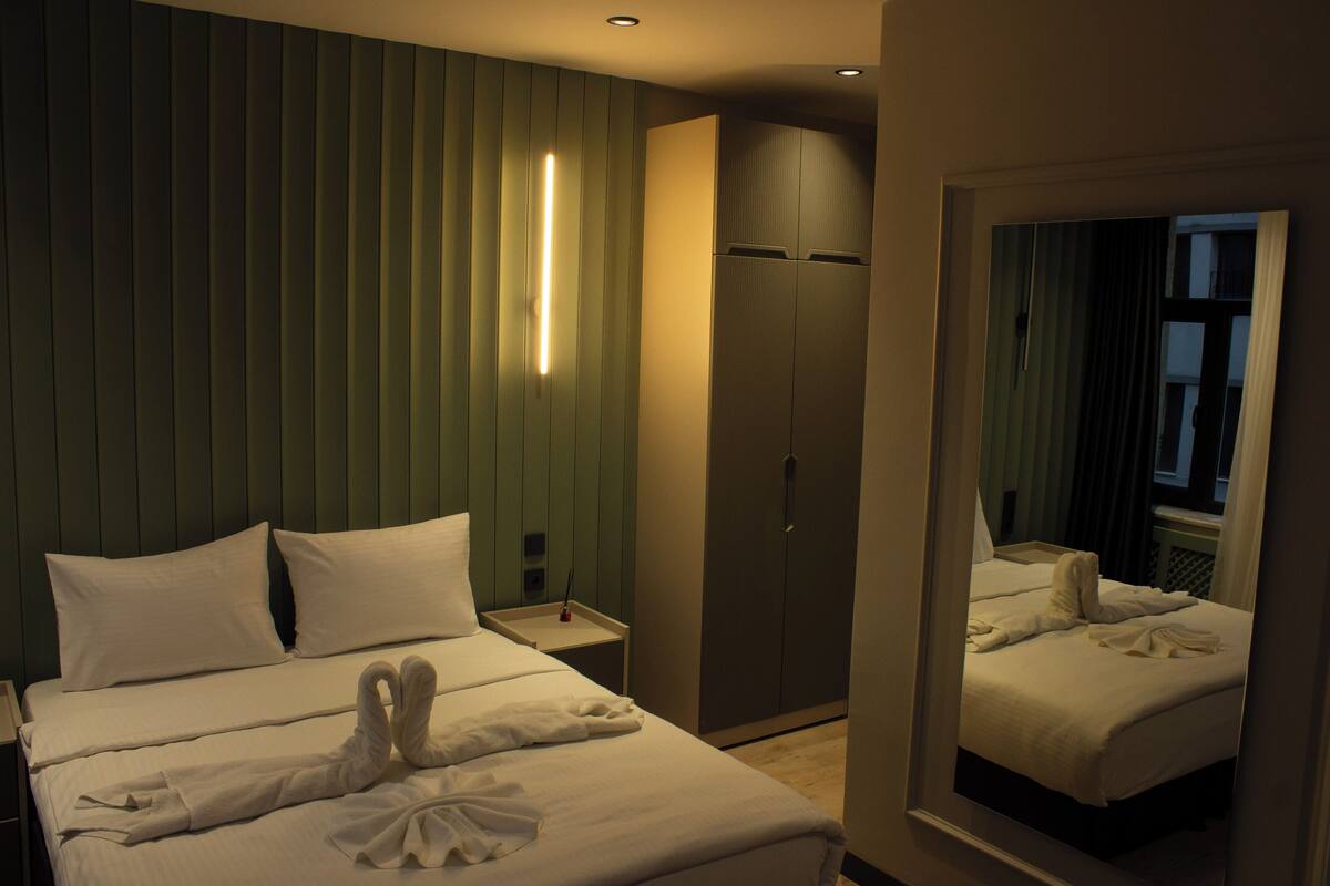 Une chambre d’hôtel comprenant un lit, une armoire, une table de chevet et un miroir.