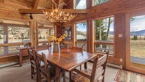 A wooden dining room with a large table, chairs, and a chandelier. - Custom Log Home-Pet-Friendly-Rio Grande River Access-Breathtaking Views (Creede)
