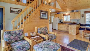 A wooden interior with a staircase, a kitchen, and seating area. - Secluded Mountain Cabin - Pet Friendly - National Forest Access (Creede)