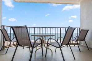 Enjoy the ocean view from this balcony with a table and four chairs.