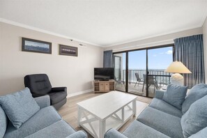 Relax in this stylish living room with a flat-screen TV, two sofas, and a balcony offering a sea view.