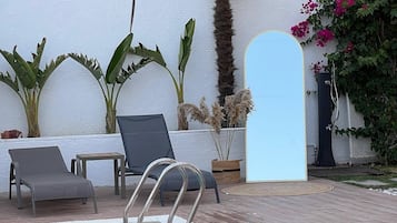Una piscina al aire libre de temporada, sombrillas