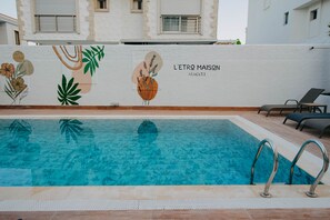 A swimming pool with a mural of abstract floral designs and the text "L'ETRO MAISON ALACATI". - Maison L'etro Alacati Hotel (Cesme)
