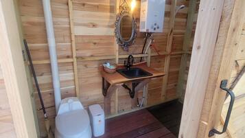Cozy cabin-style bathroom with a wooden vanity, sink, and mirror.