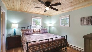 A bedroom with a bed, a ceiling fan, two bedside lamps, and a window. - It`s all new at Village Sunset, sweet little hidea (Blowing Rock)
