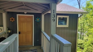 A wooden house with a porch, a door, and a mailbox. - It`s all new at Village Sunset, sweet little hidea (Blowing Rock)