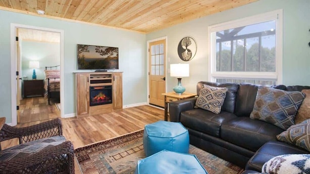 A cozy living room with a fireplace, a leather sofa, and a television. - It`s all new at Village Sunset, sweet little hidea (Blowing Rock)