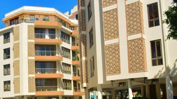 A hotel with a swimming pool, multiple balconies, and a modern architectural design. - Stay.Plus Mount Kenya Road Nyali (Mombasa)