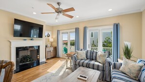 A living room with a fireplace, a sofa, a coffee table, and a television. - Pool, ocean views from rooftop deck, one street from the beach and shops! (Isle of Palms)