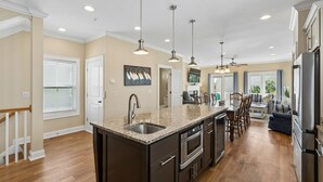 A modern kitchen with granite countertops, stainless steel appliances, and pendant lighting. - Pool, ocean views from rooftop deck, one street from the beach and shops! (Isle of Palms)