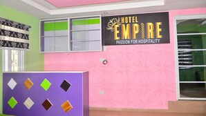 Uma área de recepção de hotel com uma placa que diz 'HOTEL EMPIRE PASSION FOR HOSPITALITY'.
