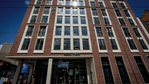 A multi-story brick building with large windows and a prominent entrance. - Motel One Dublin (Dublin)