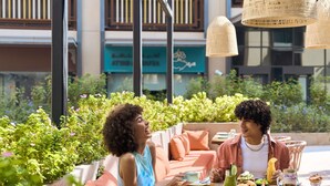 An outdoor seating area with a round table, surrounded by greenery and plants. - Ibis Styles Dubai Deira (Dubai)