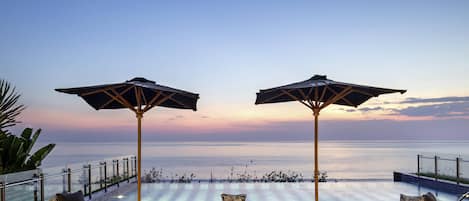 Een buitenzwembad, parasols voor strand/zwembad