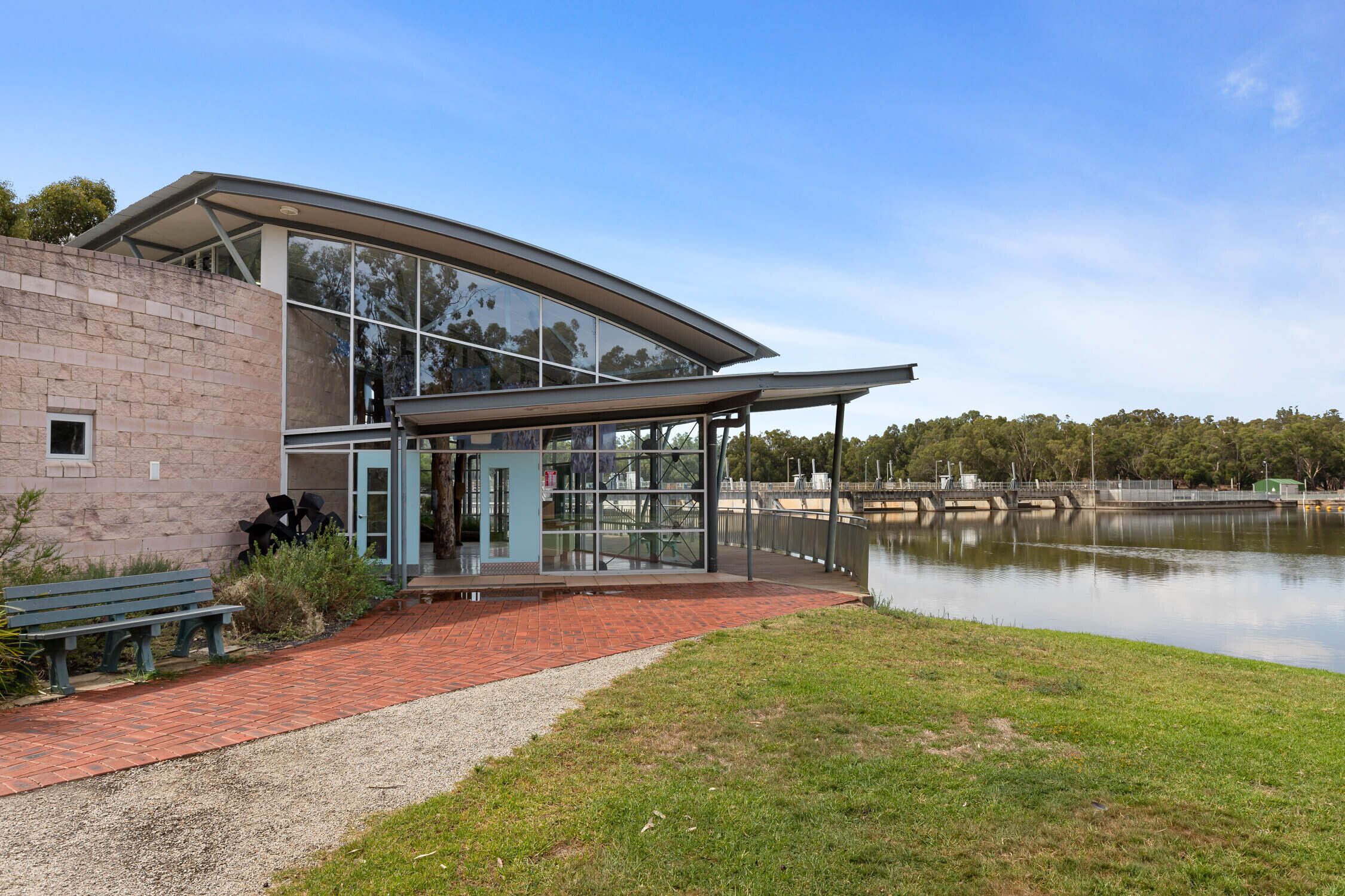 A modern building with a glass facade and a covered entrance area.