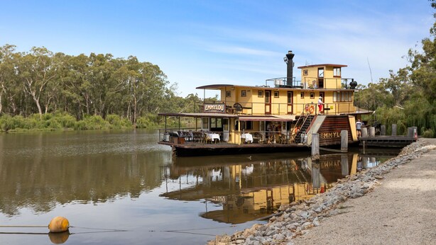 A yellow boat with a restaurant on the side, docked at a calm river with trees in the background. - Torrumbarry Motel (Torrumbarry)