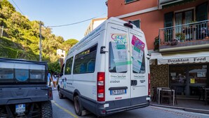 A white van with 'Cinque Terre' and 'Trekking' on the back, parked on a street with a restaurant named 'Breakfast Food' in the background. - La Casa di Frida Family Apartment (Vernazza)