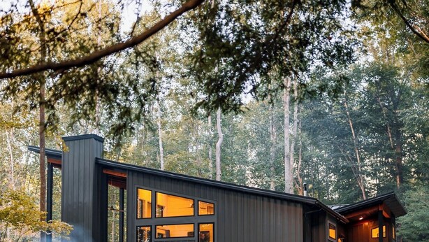 A modern cabin with multiple windows, a fireplace, and outdoor seating. - I'll Have S'More - Hocking Hills -Lux In & Out (Hocking Hills)