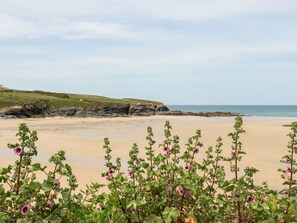 A beach with a rocky cliff in the background and a clear sky. - Constantine Bay Cottage (Padstow)