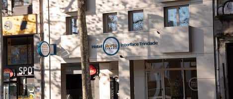 A modern building with a sign for Hotel Porto Interface Trindade.