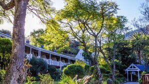 Un hôtel doté d’un espace extérieur abrité, entouré d  ’une végétation luxuriante et d’arbres.