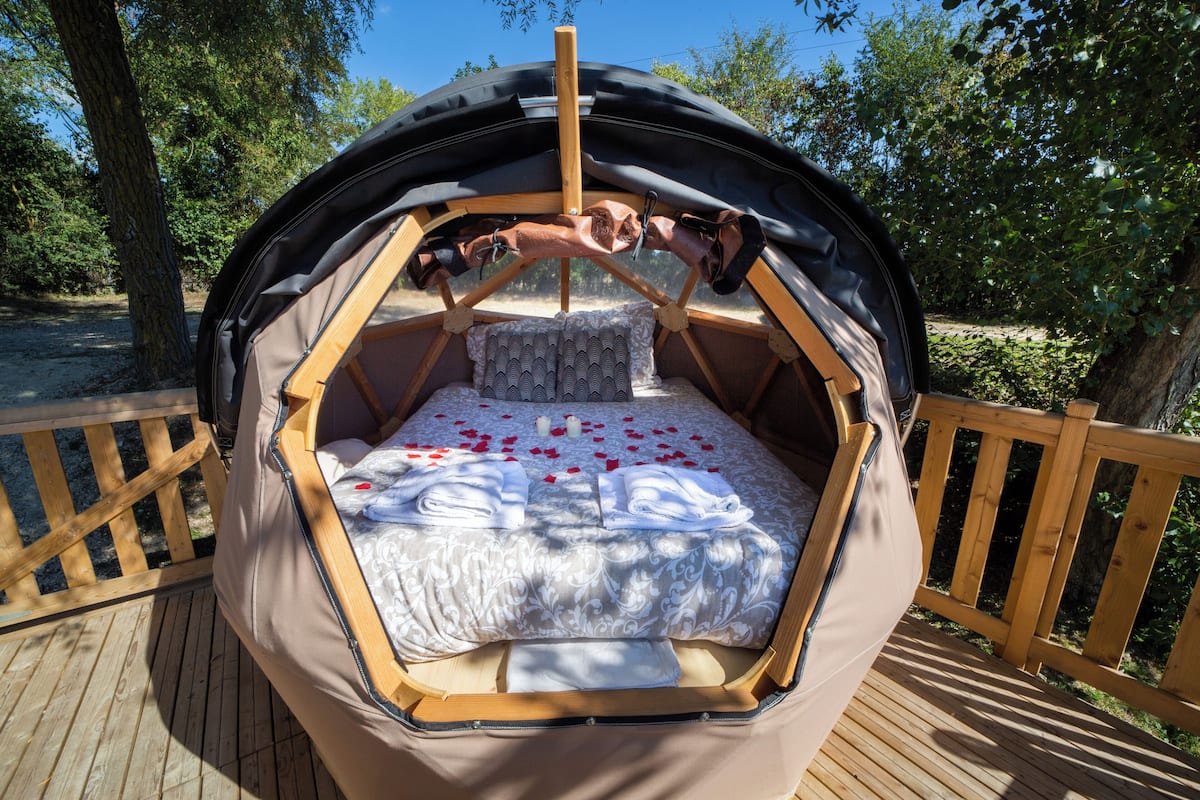 Un rincón acogedor para dormir, con cama, almohadas y dosel.