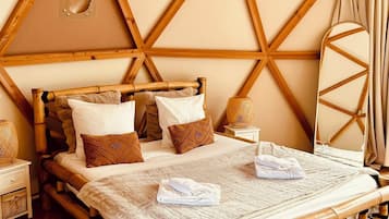 A room with a wooden bed, a round mirror, and a circular window.