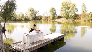 Guests can relax on the lakeside dock, surrounded by lush trees and shrubs.