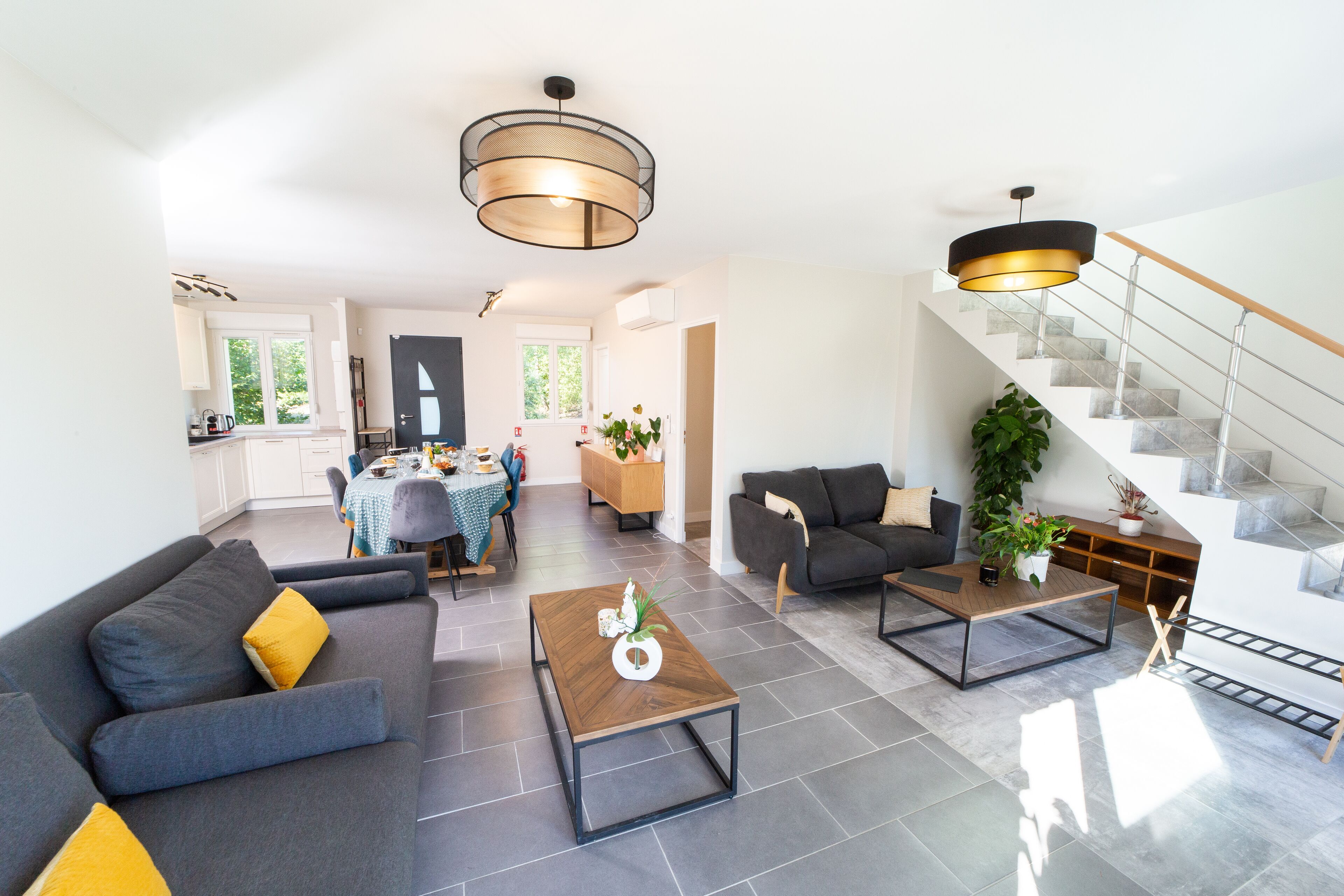 A modern living room with a sofa, coffee table, and a staircase.