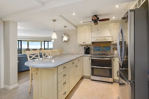 Enjoy meals in the kitchen with a central island, stainless steel appliances, and a dining area with ocean views.
