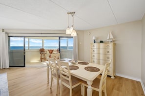 Enjoy a room with a balcony offering a sea view, a dining table, and a dresser.