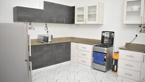 Cozinha equipada com geladeira, micro-ondas, fogão e armários.