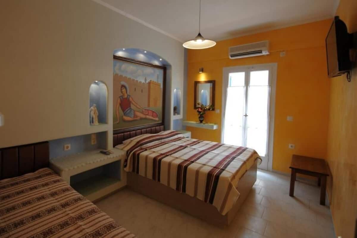 Un dormitorio con dos camas, un mural, una ventana y un equipo de aire acondicionado.
