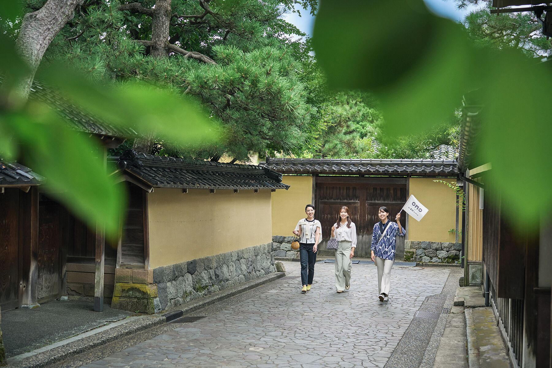 A traditional building with a tiled roof and wooden doors, a stone pathway, and a small wooden structure to the left.