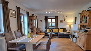 Un salon chaleureux avec une table à manger, des canapés et un buffet en bois.