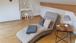 Une pièce confortable avec un canapé incurvé, un petit bureau et une lampe.